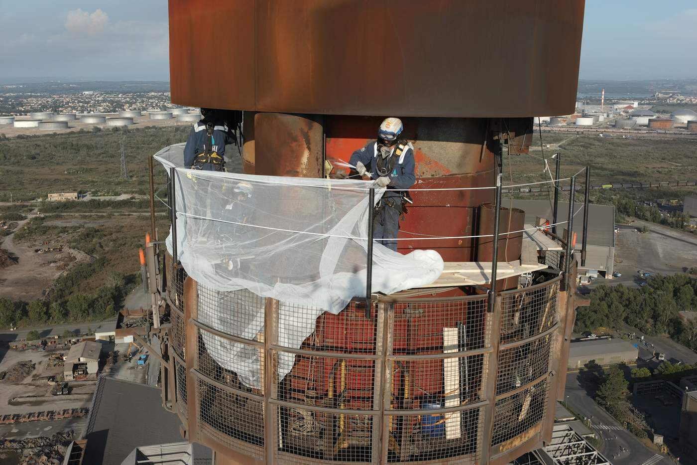 Compagnons au travail sur la plateforme d'une torchère à 120 mètres de hauteur